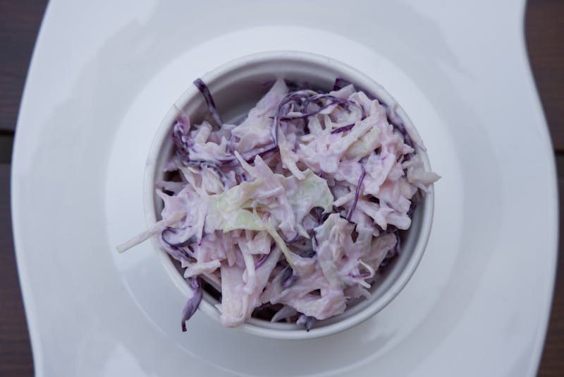 Creamy house-made coleslaw in a bowl with herbs
